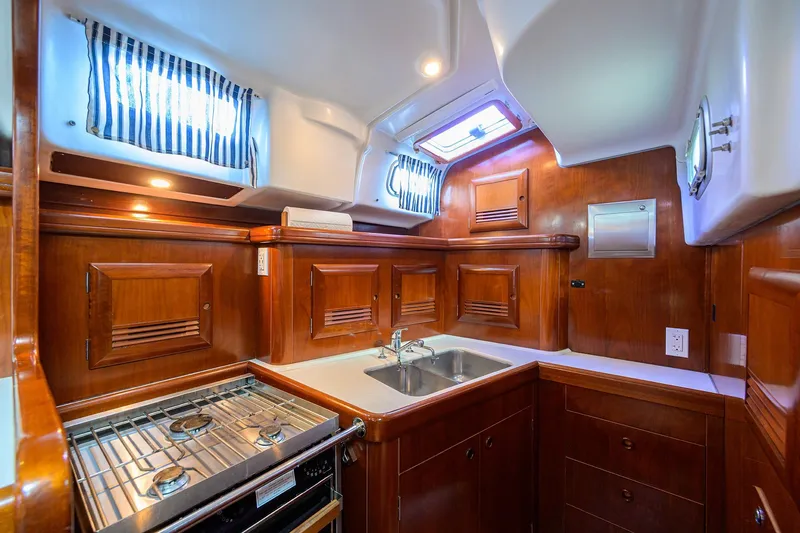 Slide: The Image of Luxurious 2003 Beneteau 50 yacht kitchen with wood cabinetry and modern appliances. - 64