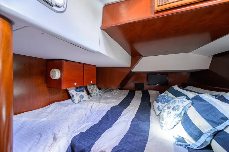 Slide: The Image of Cozy cabin interior of 2003 Beneteau 50 yacht with striped bedding and wooden cabinetry. - 69