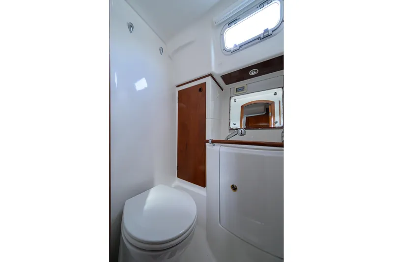 Slide: The Image of Bathroom interior of 2003 Beneteau 50 yacht, featuring toilet, mirror, and wooden accents. - 72
