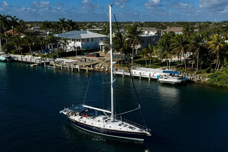 Slide: The Image of Sailboat Beneteau 50 (2003) cruising near a tropical waterfront with palm trees. - 74