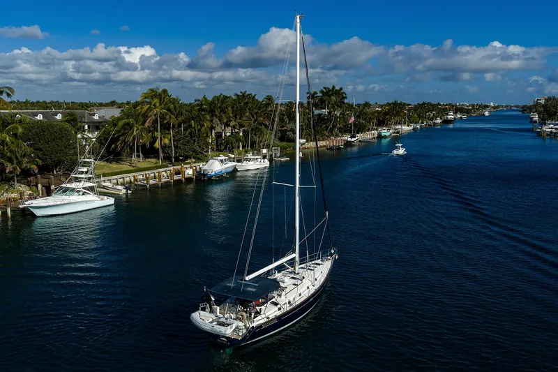 Slide: The Image of Sailing yacht Beneteau 50 (2003) cruising a scenic, palm-lined waterway. - 81