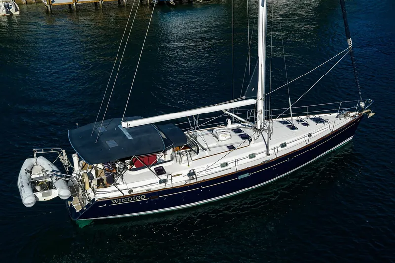 Slide: The Image of 2003 Beneteau 50 sailboat on water, aerial view, with dinghy attached. - 84