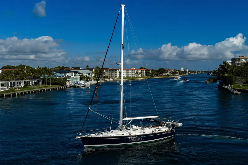 Slide: The Image of Sailing yacht Beneteau 50 (2003) cruising on a scenic waterway under a clear blue sky. - 91