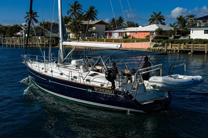 Slide: The Image of 2003 Beneteau 50 sailboat cruising near waterfront homes, clear skies, and palm trees. - 94