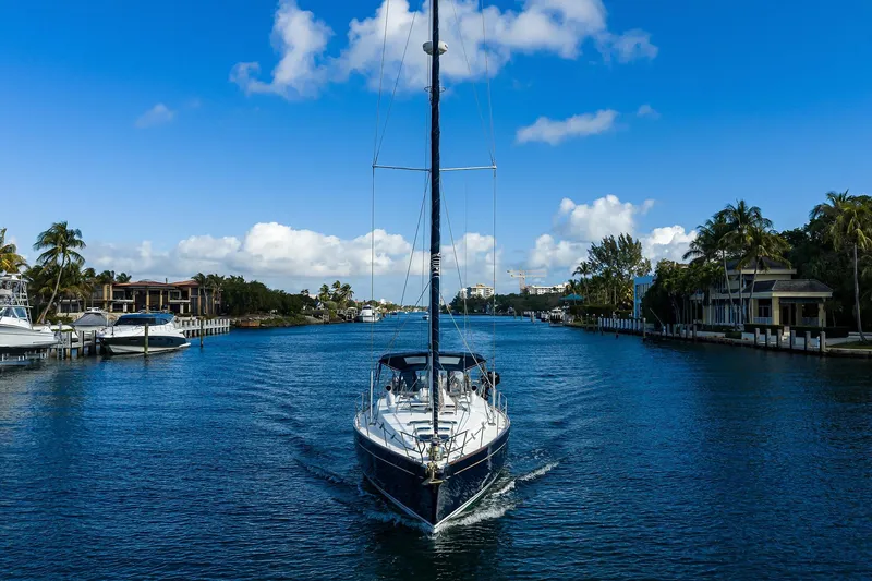 Slide: The Image of Sailing yacht Beneteau 50 (2003) cruising through a scenic waterway with palm trees. - 98