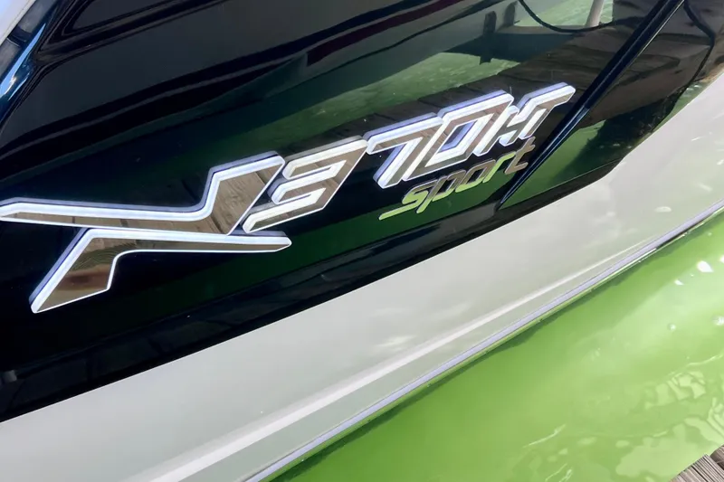 Slide: The Image of 2024 NX Boats 370 HT logo on sleek green and white hull. - 10