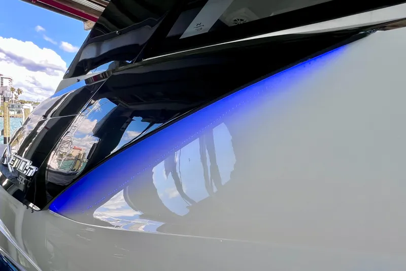 Slide: The Image of 2024 NX Boats 370 HT with sleek design and reflective surfaces, docked by the water. - 12