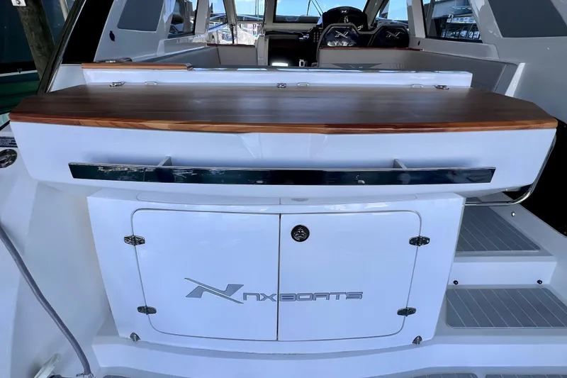 Slide: The Image of 2024 NX Boats 370 HT interior with sleek design and wooden accents. - 15