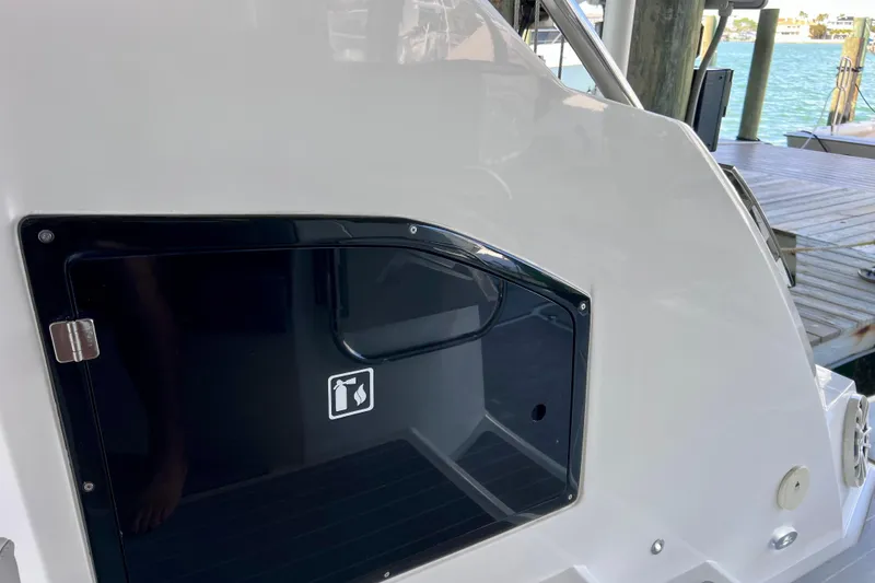 Slide: The Image of 2024 NX Boats 370 HT, sleek exterior detail with storage compartment by the water. - 22