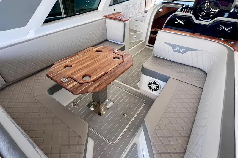 Slide: The Image of Luxurious interior of 2024 NX Boats 370 HT with elegant seating and wooden table. - 24