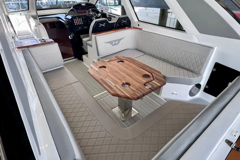 Slide: The Image of 2024 NX Boats 370 HT interior with elegant seating and wooden table. - 25