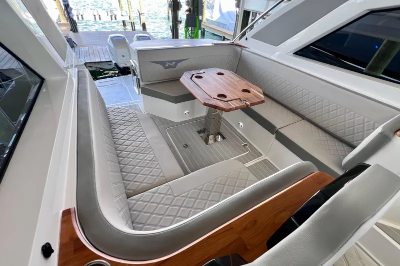 Slide: The Image of 2024 NX Boats 370 HT interior with elegant seating and wooden table. - 26
