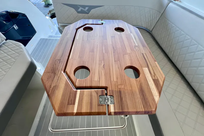 Slide: The Image of Wooden table with cup holders on 2024 NX Boats 370 HT interior. - 28