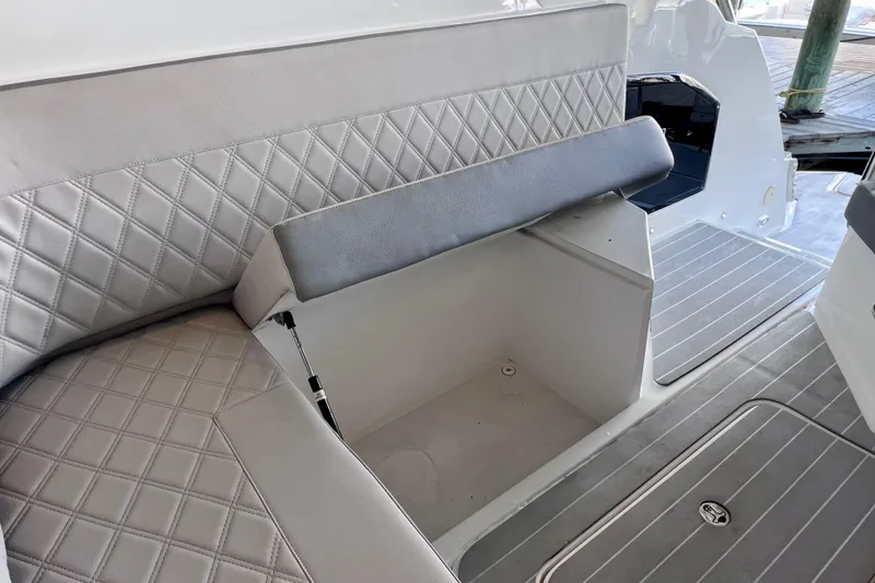 Slide: The Image of 2024 NX Boats 370 HT interior seating with storage compartment, featuring diamond-pattern upholstery. - 34