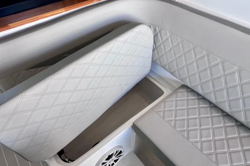 Slide: The Image of 2024 NX Boats 370 HT interior with diamond-stitched upholstery and storage compartment. - 35