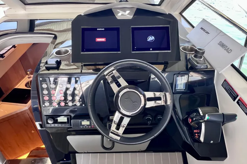 Slide: The Image of 2024 NX Boats 370 HT helm with advanced controls and dual Simrad displays. - 36
