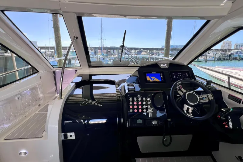 Slide: The Image of 2024 NX Boats 370 HT helm with modern controls and marina view. - 50