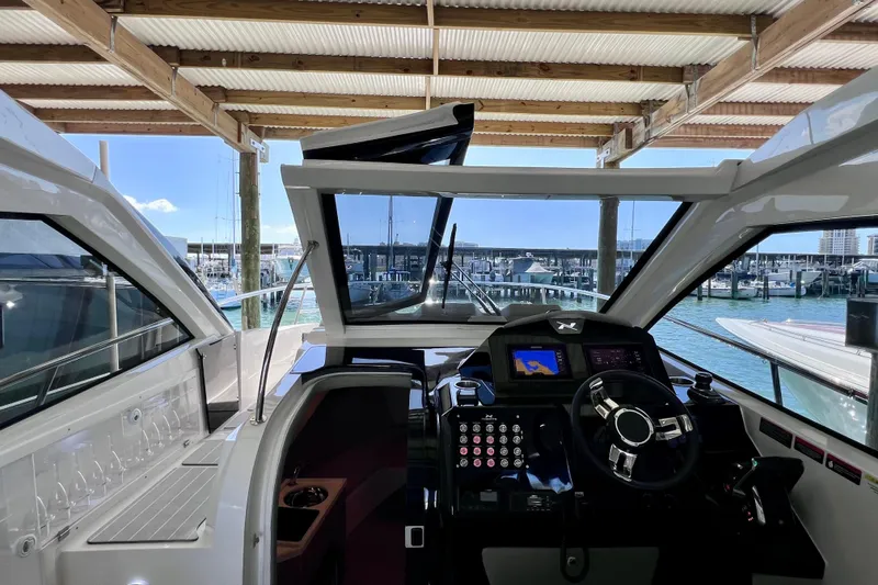 Slide: The Image of 2024 NX Boats 370 HT helm with modern controls, docked at marina. - 57