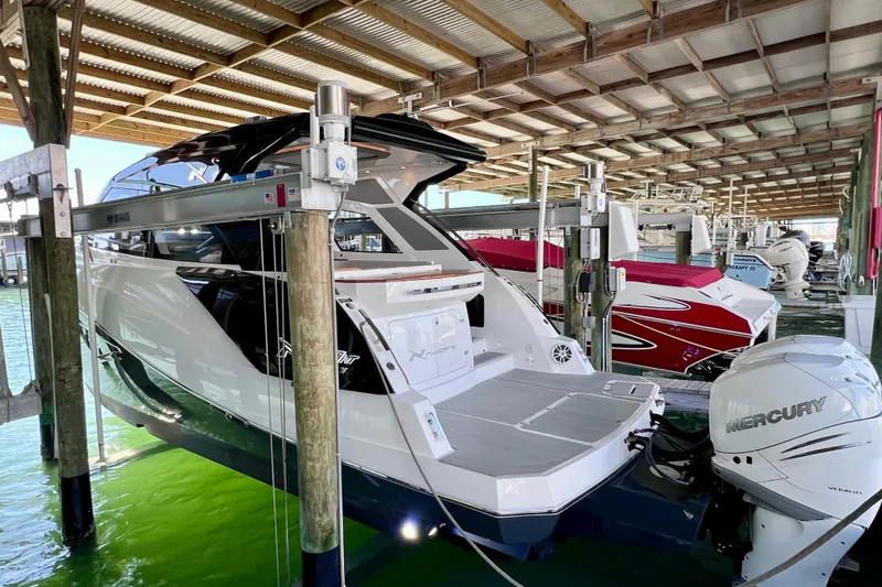 Slide: The Image of 2024 NX Boats 370 HT docked, featuring sleek design and Mercury outboard engine. - 6