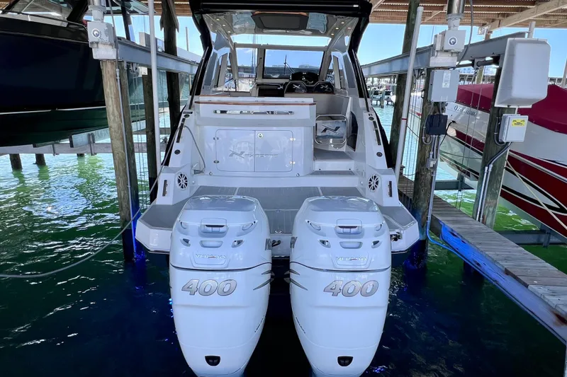Slide: The Image of 2024 NX Boats 370 HT with twin 400 horsepower engines docked in marina. - 7