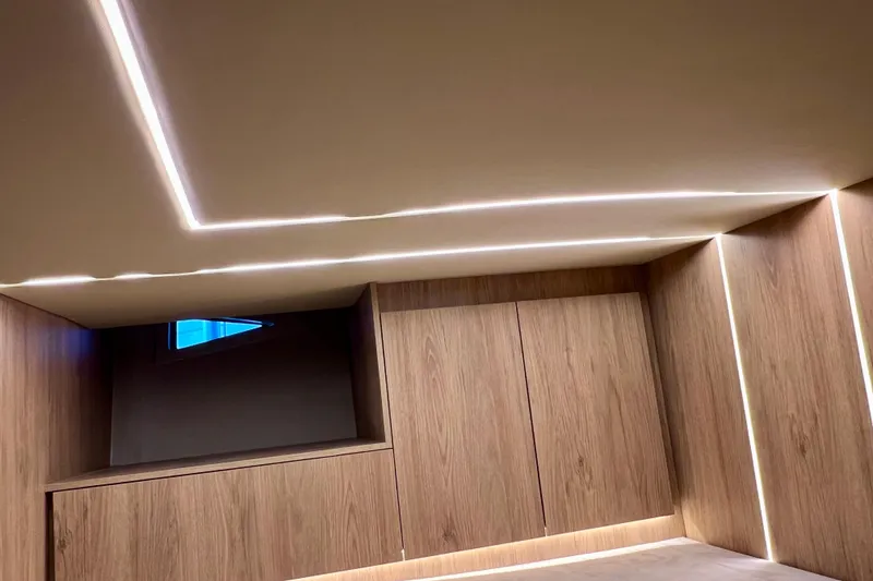 Slide: The Image of 2024 NX Boats 370 HT interior with modern wood paneling and ambient lighting. - 75