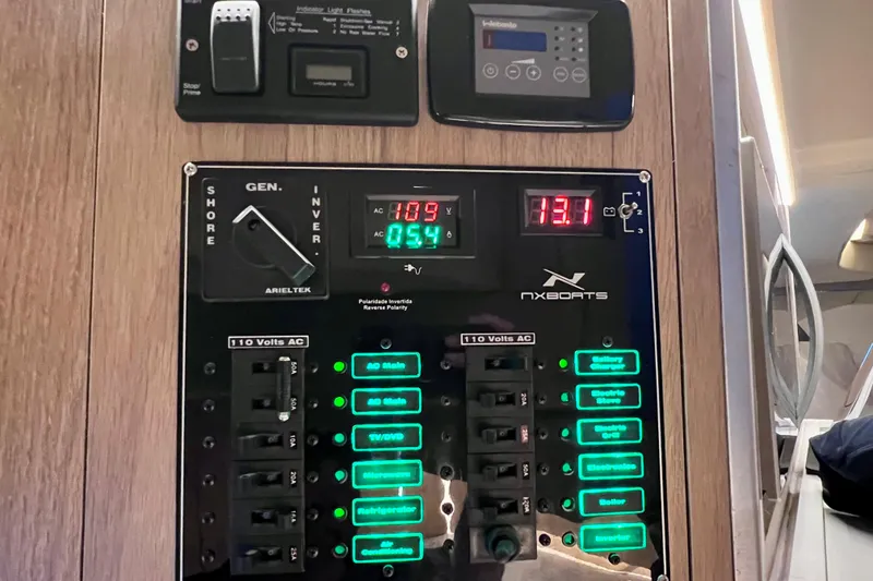 Slide: The Image of Electrical control panel of 2024 NX Boats 370 HT with illuminated switches and digital displays. - 76