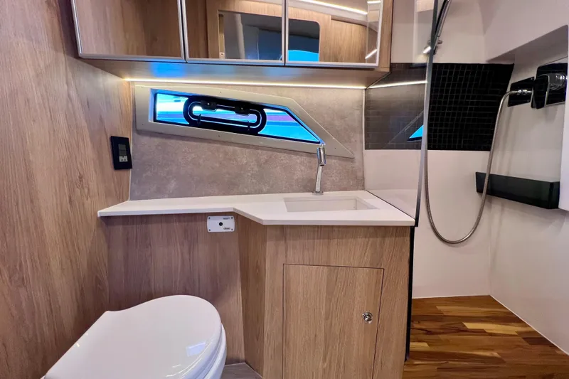 Slide: The Image of Modern bathroom interior of 2024 NX Boats 370 HT with wood accents and sleek fixtures. - 80
