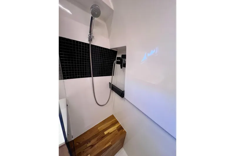 Slide: The Image of Modern shower in 2024 NX Boats 370 HT with sleek black tiles and wooden flooring. - 82