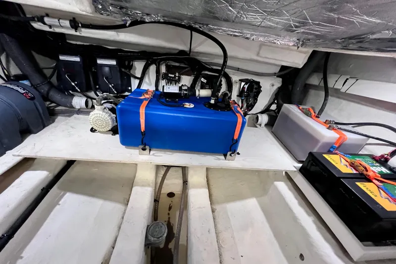 Slide: The Image of Engine compartment of 2024 NX Boats 370 HT, featuring batteries and blue fuel tank. - 84