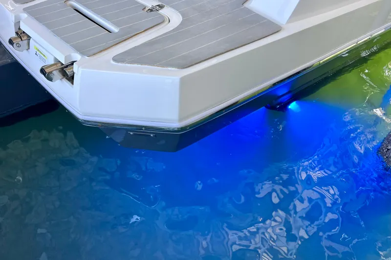 Slide: The Image of 2024 NX Boats 370 HT with blue underwater lights reflecting on water. - 92