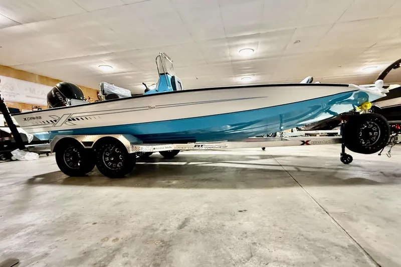 The Image of 2026 Express H22 Bay boat on trailer in indoor showroom. - 1