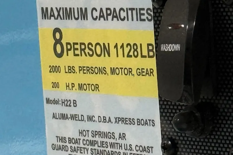 Slide: The Image of 2026 Express H22 Bay boat capacity label: 8 persons, 1128 lbs, 200 HP motor. - 16