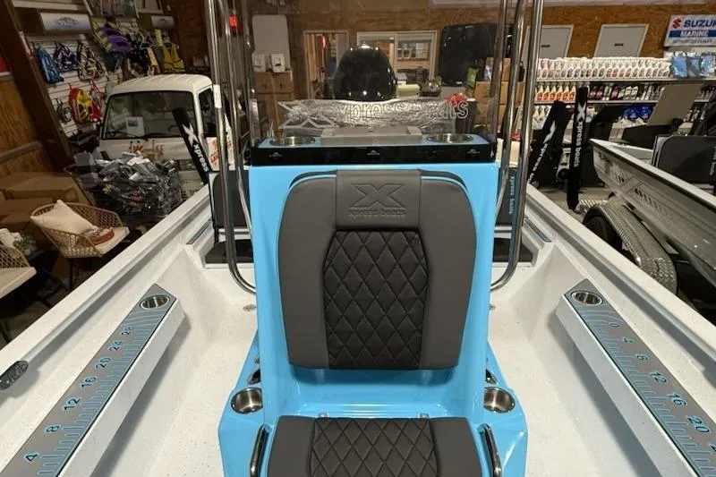 Slide: The Image of 2026 Express H22 Bay boat interior with blue and black seating in a showroom. - 5