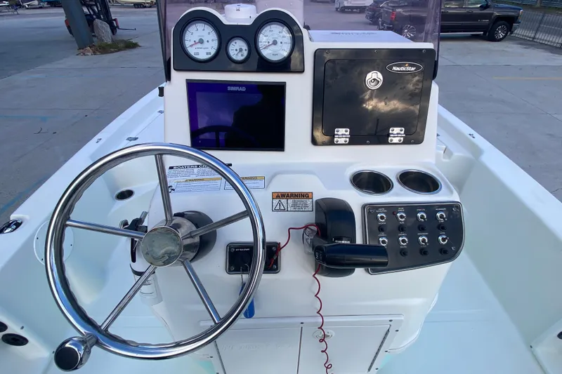 Slide: The Image of 2018 NauticStar 215 XTS boat console with steering wheel and control panel. - 15