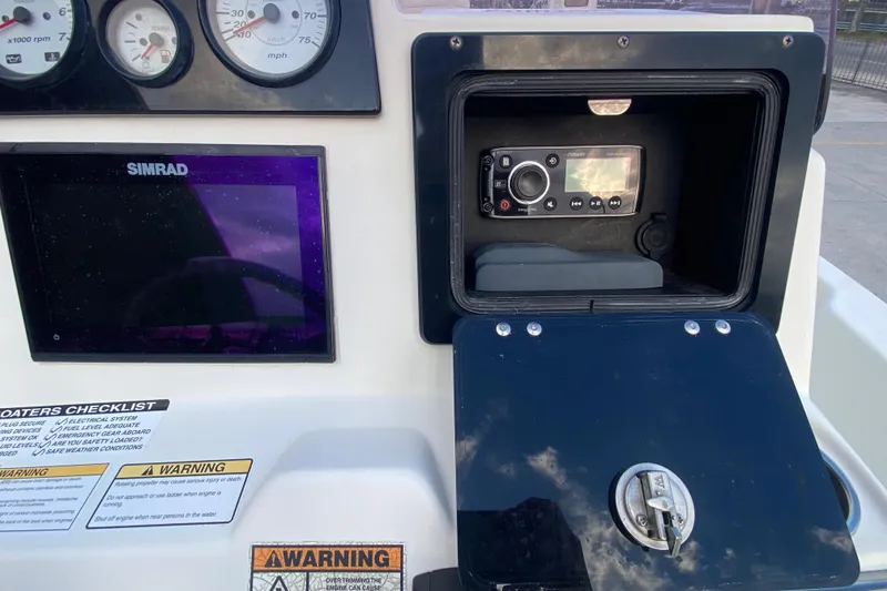 Slide: The Image of 2018 NauticStar 215 XTS dashboard with Simrad display and Fusion stereo system. - 16