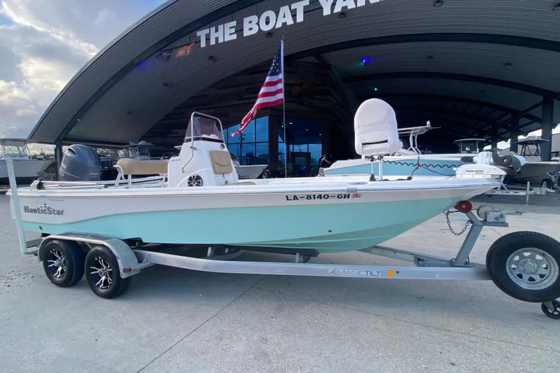 Slide: The Image of 2018 NauticStar 215 XTS boat on trailer at The Boat Yard, with American flag. - 3
