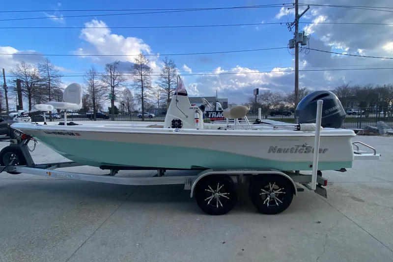 Slide: The Image of 2018 NauticStar 215 XTS boat on trailer under blue sky. - 6