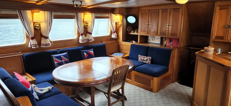 Slide: The Image of Interior of 1983 Thackwray Custom Pilothouse Motorsailer with wooden furnishings and blue seating. - 10