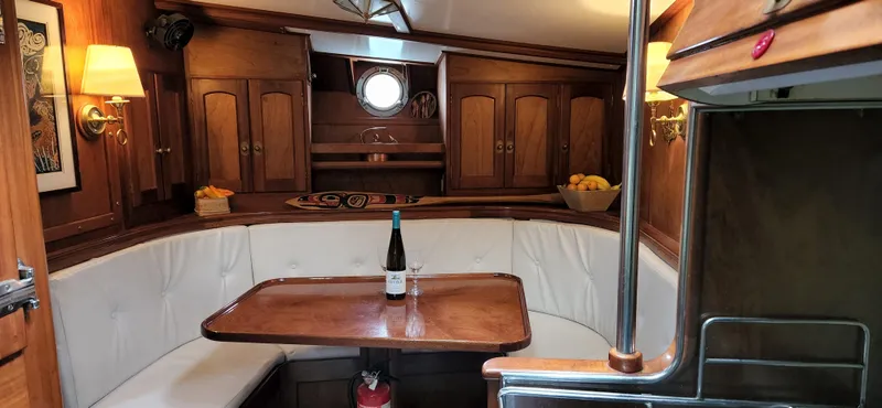 Slide: The Image of Interior of 1983 Thackwray Custom Pilothouse Motorsailer with wooden cabinetry and dining area. - 16