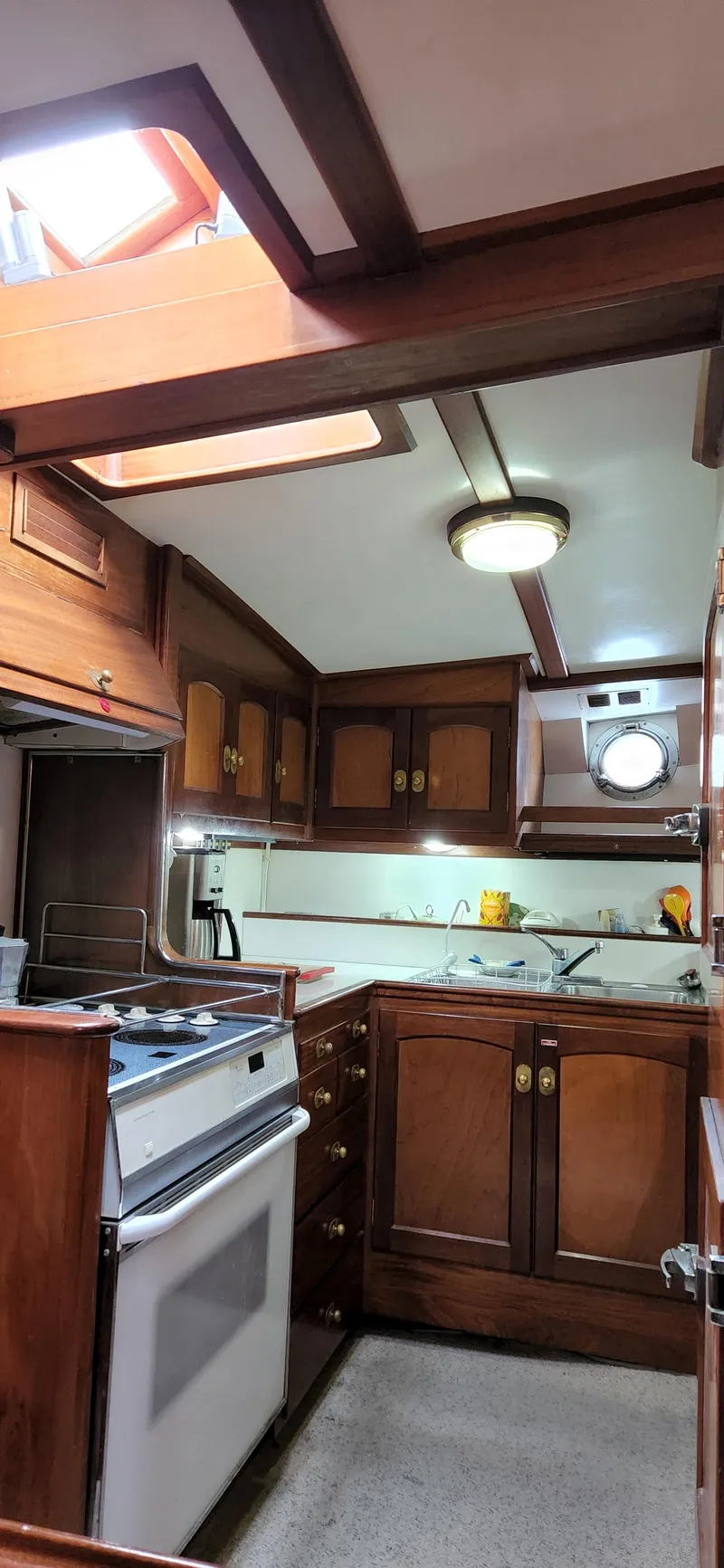 Slide: The Image of Interior of 1983 Thackwray Custom Pilothouse Motorsailer with wooden cabinetry and modern kitchen amenities. - 18