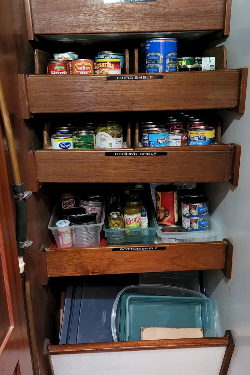 Slide: The Image of Wooden pantry shelves with canned goods on a 1983 Thackwray Custom Pilothouse Motorsailer. - 20
