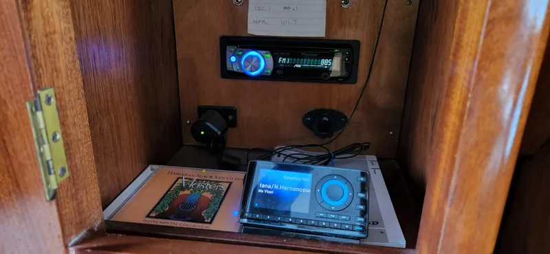 Slide: The Image of 1983 Thackwray Custom Pilothouse Motorsailer interior with modern audio equipment and wooden cabinetry. - 21