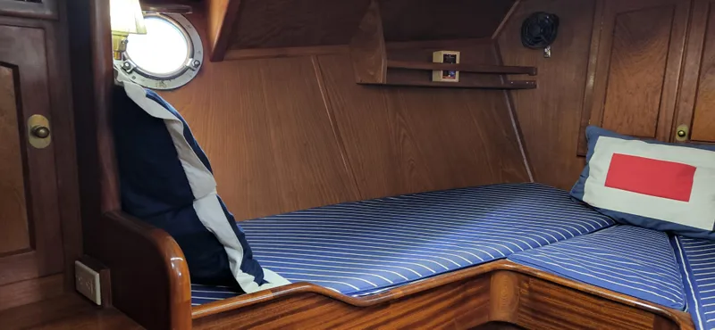 Slide: The Image of Cozy cabin interior of 1983 Thackwray Custom Pilothouse Motorsailer with striped bedding and porthole. - 24