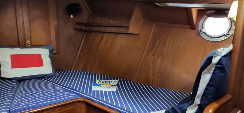 Slide: The Image of Cozy cabin interior of 1983 Thackwray Custom Pilothouse Motorsailer with striped bedding and porthole. - 25