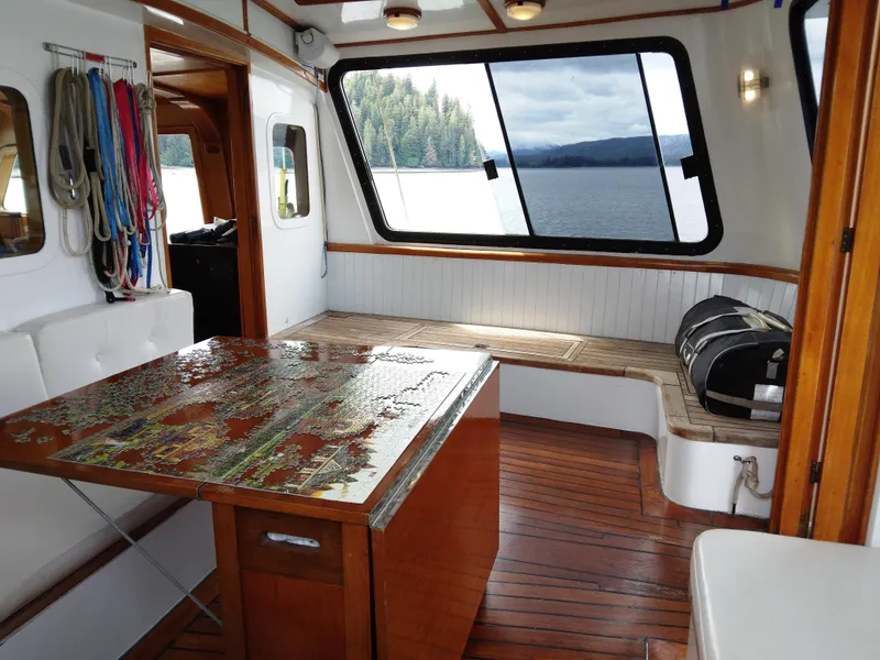 Slide: The Image of Interior of 1983 Thackwray Custom Pilothouse Motorsailer with wooden flooring and scenic window view. - 3