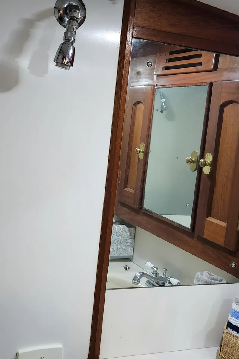 Slide: The Image of Wooden bathroom cabinet and showerhead in 1983 Thackwray Custom Pilothouse Motorsailer. - 31