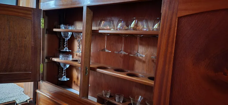 Slide: The Image of Wooden cabinet with glassware on a 1983 Thackwray Custom Pilothouse Motorsailer. - 36
