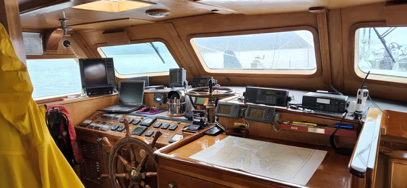 Slide: The Image of Pilothouse interior of 1983 Thackwray Custom Motorsailer with navigation equipment and wooden helm. - 4