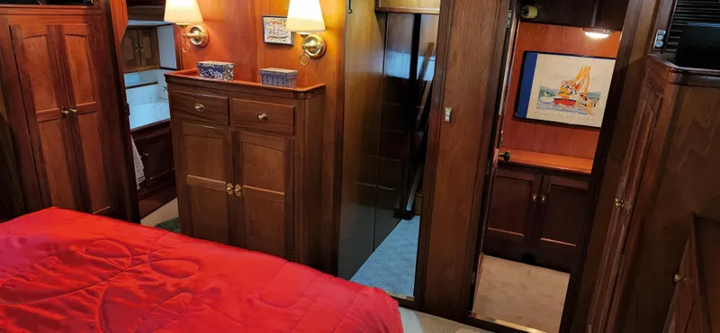 Slide: The Image of Interior of 1983 Thackwray Custom Pilothouse Motorsailer with wood cabinetry and red bedding. - 44