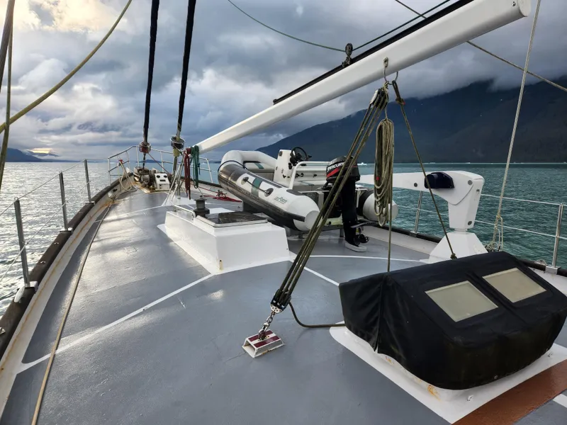 Slide: The Image of 1983 Thackwray Custom Pilothouse Motorsailer deck with scenic ocean and mountain backdrop. - 49